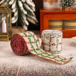 Christmas plaid ribbons with red berries and pine needles on snow-covered wood