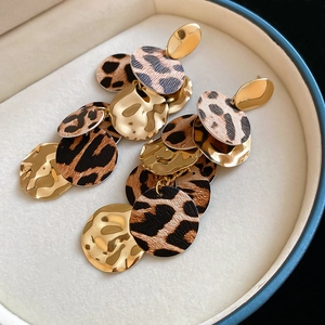 Gros plan sur les boucles d'oreilles léopard avec disques en métal doré poli