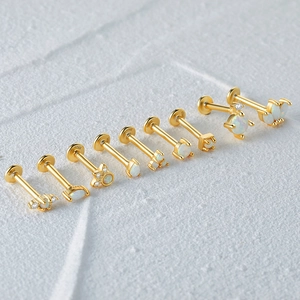 Detail of eight S925 sterling silver gold-plated opal stud earrings on marble background