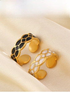 Detail of 18K gold plated rings with black and white enamel diamond patterns on silk
