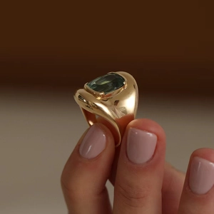 Vintage gold ring with emerald-cut green tourmaline gemstone on a textured band