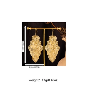 Detail view of 11cm bohemian gold filigree leaf earrings with layered fringe on a T-stand