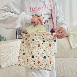 Sac bandoulière en toile matelassée avec motif ours montrant la capacité intérieure