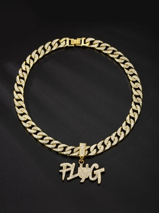 Macro shot of gold Cuban link chain with a diamond-encrusted PLUG letter pendant