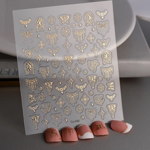 Autocollants à ongles dorés avec motifs papillon et lune sur manucure rose française