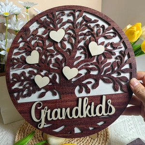 Detail of wooden Tree of Life plaque featuring heart accents and Grandkids engraving
