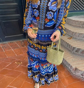 Detail of bohemian long sleeve dress with floral prints and tiered skirt design