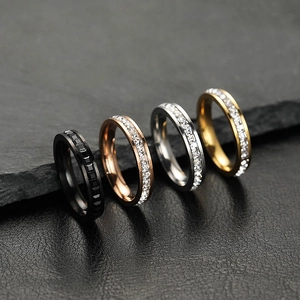 Detail showing four stainless steel rings with zircon stones in black, gold, and silver