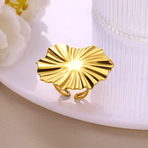 Macro detail of gold stainless steel ring featuring an artistic wavy pleated flower design