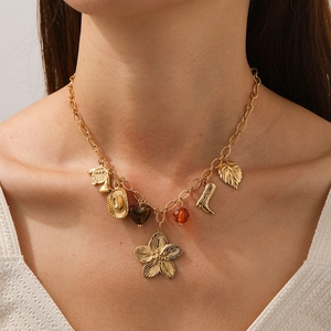 Vintage gold plated necklace with flower, heart, and boot pendants on a chain link