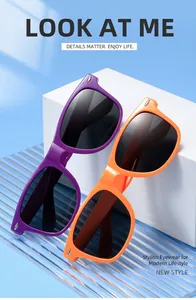 Close-up of stylish purple and orange sunglasses with silver metal rivets on a white stand