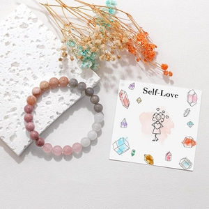 Detail view of 8mm Moonstone and Sunstone beaded bracelet on a Self-Love themed card