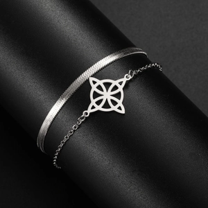 Macro shot of silver stainless steel double layer snake chain with a Celtic knot pendant