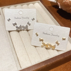 Macro shot of 18k gold plated bow stud earrings set with zircon in a velvet jewelry box