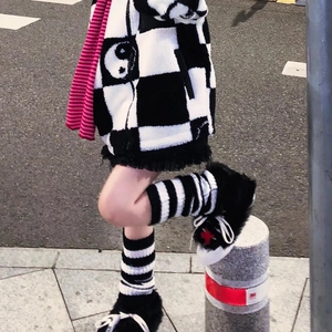 Japanese style black and white striped leg warmers paired with plush sneakers and scarf