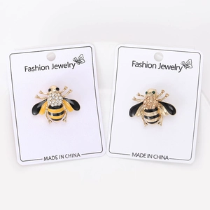 Detail view of two bee brooches with enamel and sparkling rhinestones on display cards