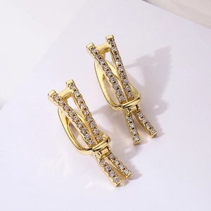 Goldene Knotohrringe mit funkelnden Zirkonia auf weißem Grund, minimalistischer Schmuck