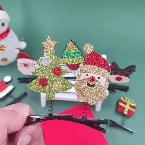 Weihnachtshaarspangen mit glitzerndem Weihnachtsmann und grünem Baum auf Federn