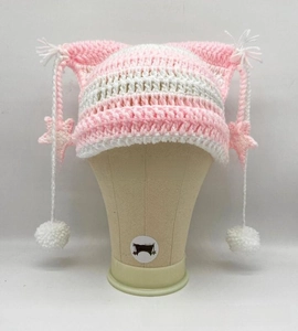 Detail of pink and white striped cat ear beanie with star patches and pompom ties