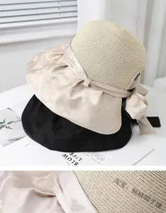 Detailed view of women's straw sun hat with elegant silk bow and woven texture