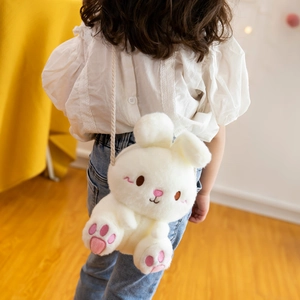 Cute white plush rabbit crossbody bag for kids shown on child model in cozy home setting