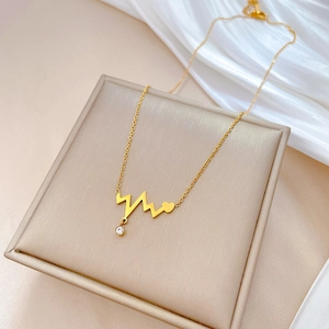 Close-up of golden heartbeat necklace with heart pendant and sparkling cubic zirconia