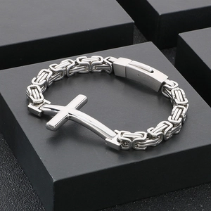 Macro view of Byzantine chain link and cross detail on a stainless steel bracelet