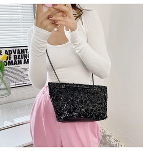 Close-up of a black sequined crossbody bag with a sleek metallic chain strap for women