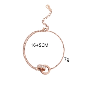 Détail du bracelet à double chaîne en or rose avec anneaux sertis de diamants et chiffres