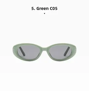 Detail view of green oval cat-eye sunglasses with grey lenses and silver dot accents
