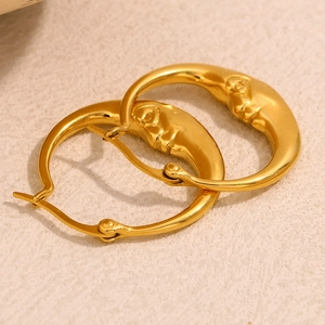 Makroaufnahme von 18K vergoldeten Edelstahlohrringen mit abstraktem Mondgesicht-Design
