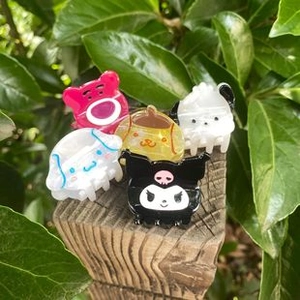 Close-up of colorful cartoon floral hair clips displayed on a wooden stand