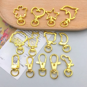Detailansicht goldener Karabinerverschlüsse in Herz-, Stern- und Delfinformen