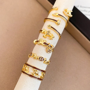 Detailed close-up of gold plated horse and coin rings with brown enamel and zircons