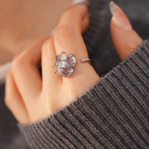Détail d'une bague trèfle aux pétales violets et anneau argenté torsadé