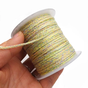 Close-up of multicolor braided cotton cord on spool showing detailed texture and weave