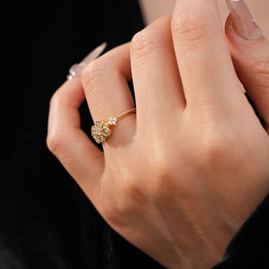 Macro shot of gold-plated flower ring with sparkling zircon stones on a model hand