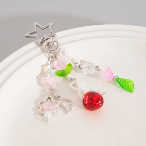 Dettaglio portachiavi a fragola con chiusura a stella, perle e fiori rosa dolci