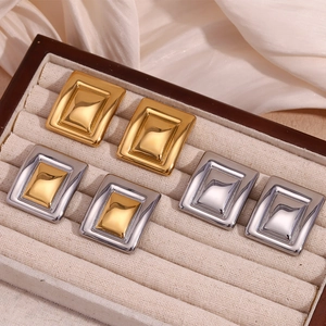 Detailed view of layered geometric rectangular earrings in gold and silver metal finishes