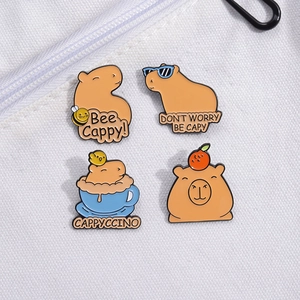 Set of 4 cute capybara enamel pins with creative slogans on a white fabric background