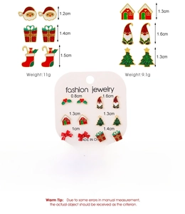 Macro detail of alloy Christmas earring set with snowman, tree and gift box charms