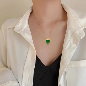 Minimalist titanium steel necklace featuring a green heart-shaped gemstone pendant on a gold chain