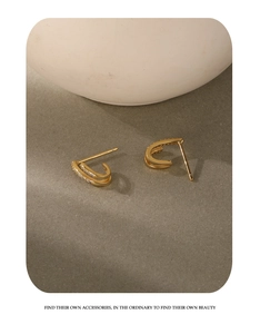 Detailed macro view of S925 silver gold-plated C-shaped earrings with paved cubic zirconia