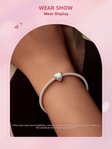 Detail of 925 sterling silver chain bracelet with a heart-shaped opal stone on wrist