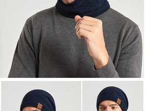 Detail of dark blue knit beanie and neck warmer set with diamond texture and leather logo