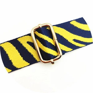 Close-up of adjustable strap with tiger print pattern and gold metal buckle detail