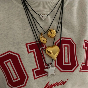 Close-up of layered wax rope necklaces with polished heart and star metal pendants
