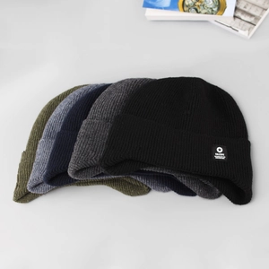 Stack of thick knitted beanies for men in black, grey, navy, and olive green colors