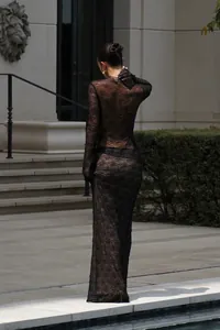 Détails du dos d'une robe longue en dentelle noire transparente avec des manches longues sexy