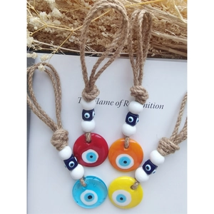 Detailed set of four colorful glass evil eye charms with rustic natural hemp ropes